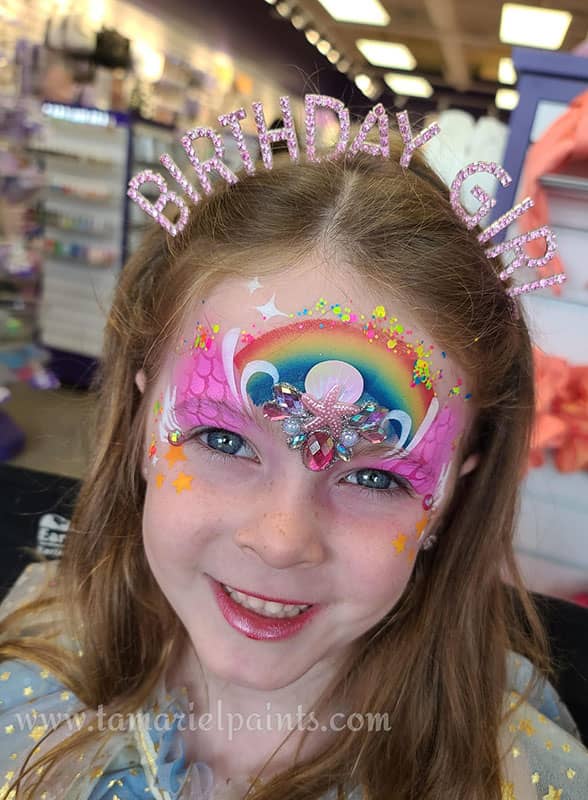 A girl with colorful ocean themed airbrush face paint