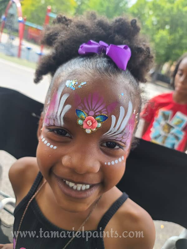 A girl with colorful flower airbrush face paint