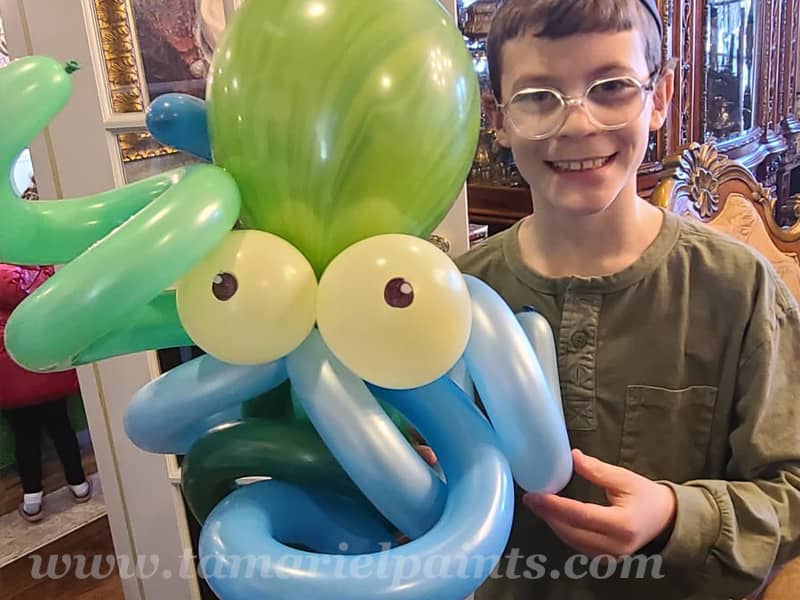 A photo of a child with a fun octopus twisted balloon