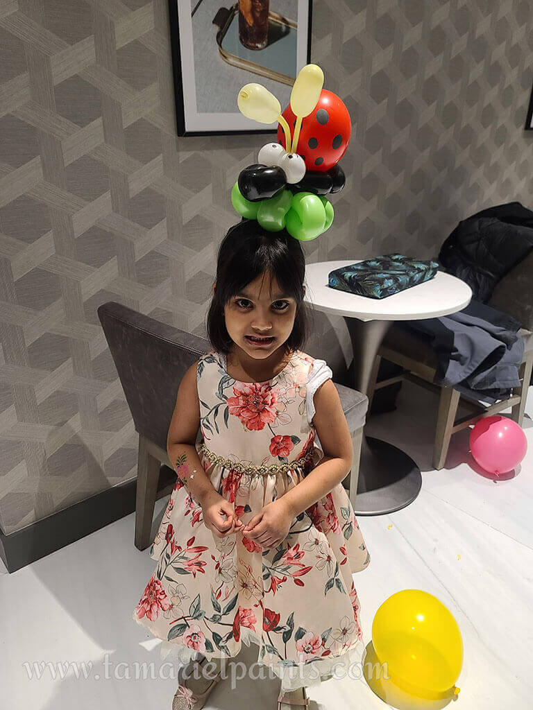 A creative display of white, copper and black balloons in a single column with a Congratulations Graduate balloon at the top