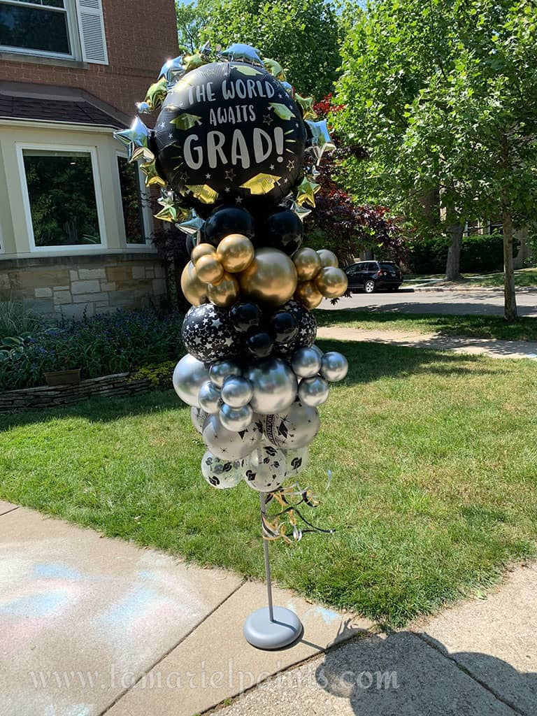 A creative display of white, copper and black balloons in a single column with a Congratulations Graduate balloon at the top