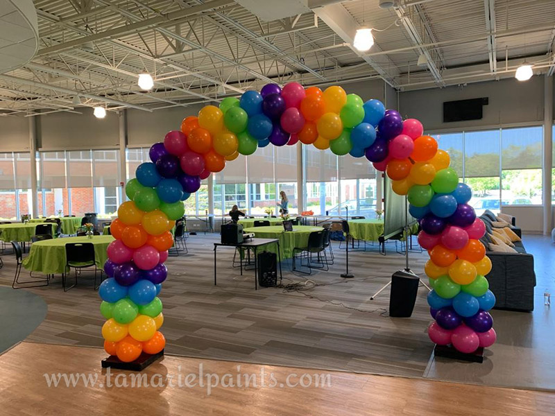 A photo of a rainbow arch balloon display