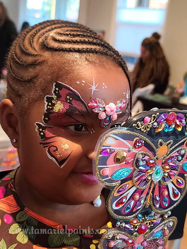 A girl with colorful butterfly themed face paint