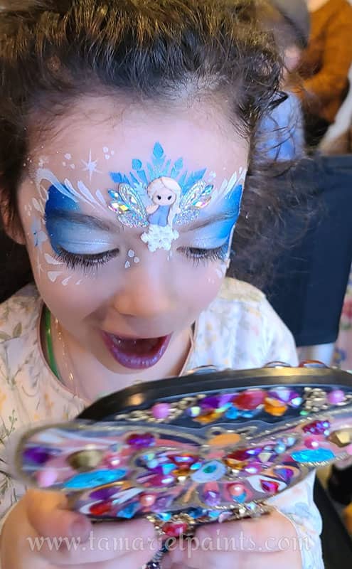 A girl with colorful Frozen themed face paint