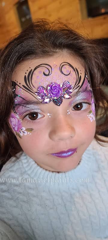 A girl with colorful floral themed face paint