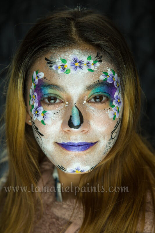 A woman with colorful flower face paint