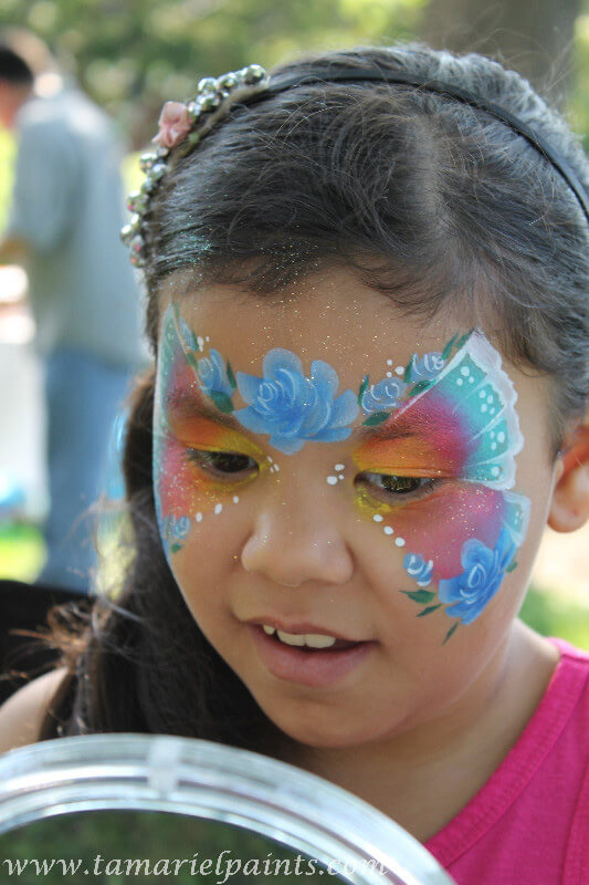 A girl with colorful butterfly floral face paint