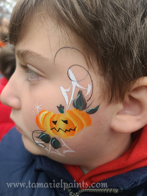 A boy with Halloween pumpkin face paint