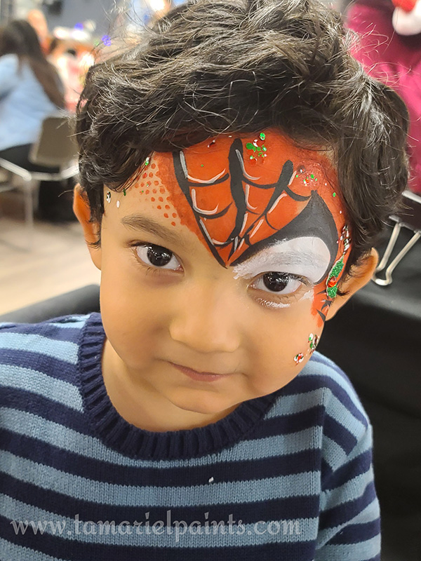 A boy with Spiderman style face paint