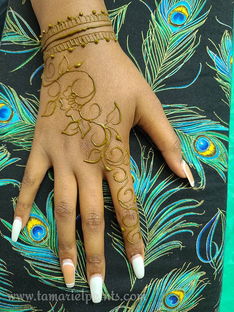 A hand with an intricate floral henna tattoo pattern