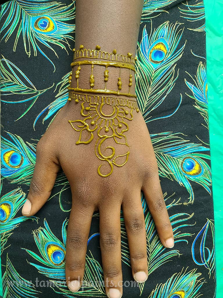 A hand with an intricate floral henna tattoo pattern