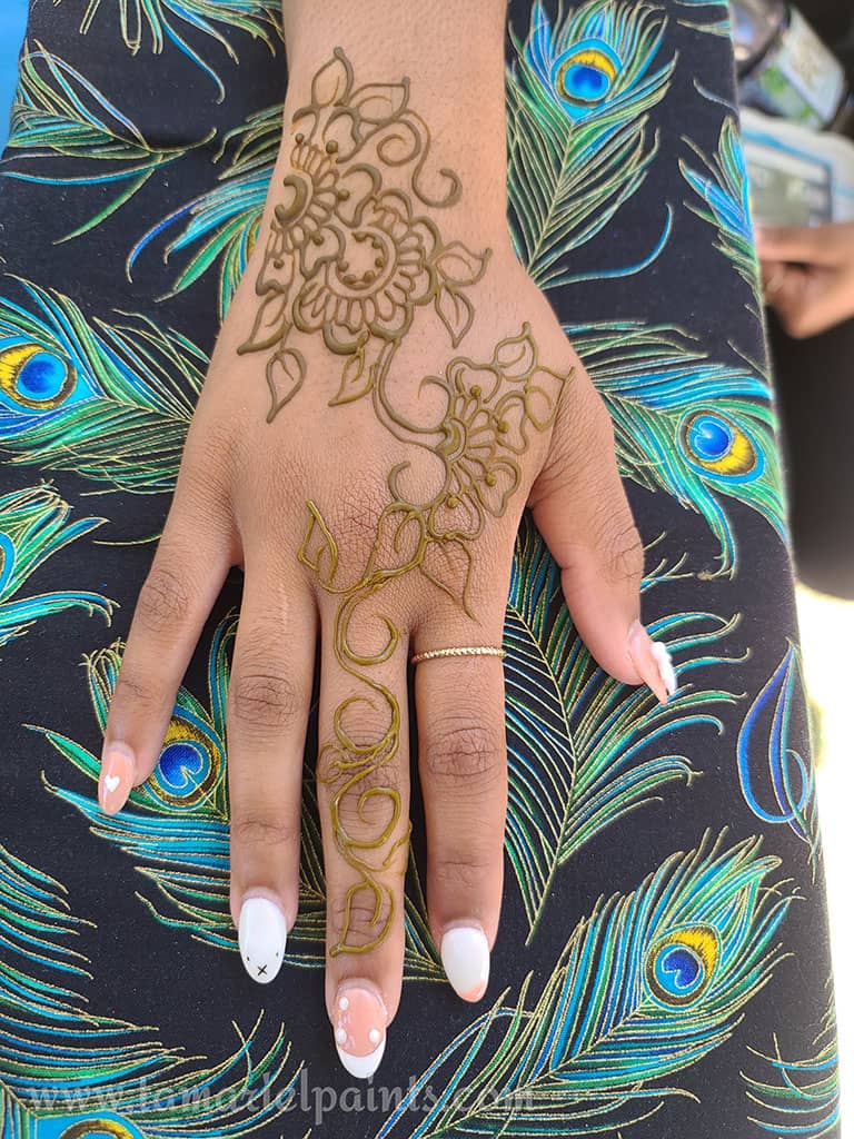 A hand with an intricate floral henna tattoo pattern