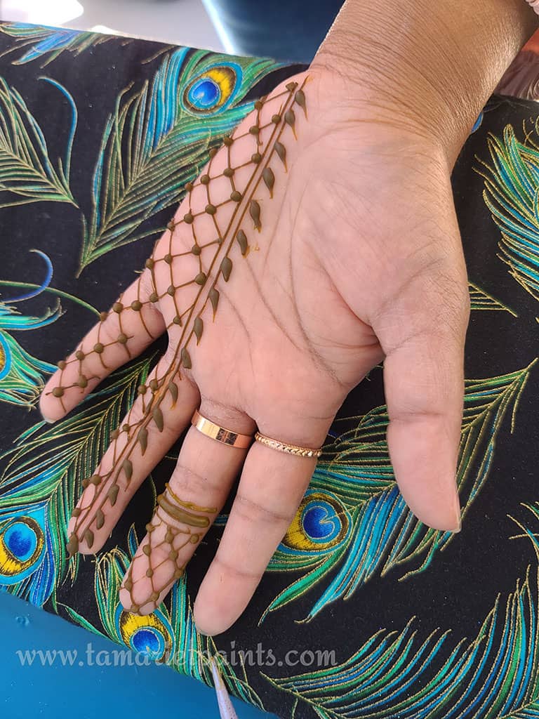 A hand with an intricate repeting pattern henna tattoo pattern