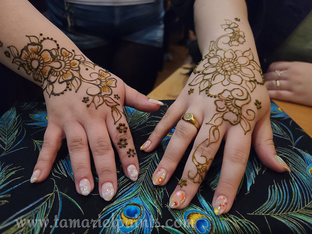 A hand with an intricate floral henna tattoo pattern