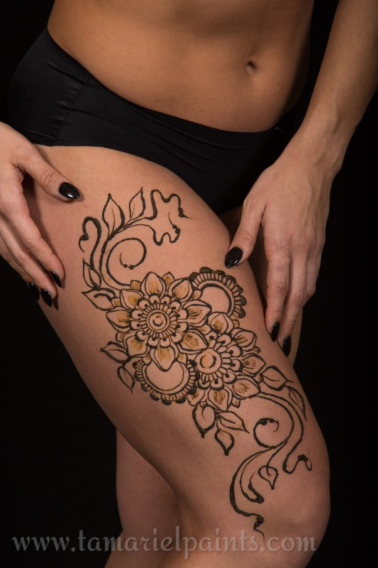 An intricate floral henna leg tattoo