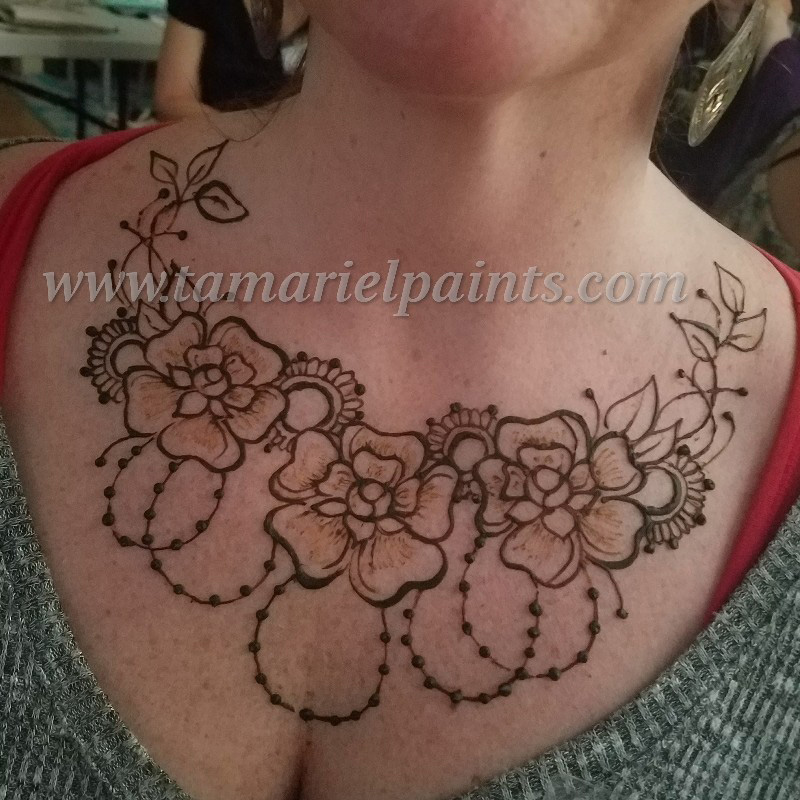 An intricate floral henna chest tattoo