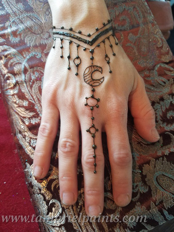 A hand with an intricate henna tattoo pattern