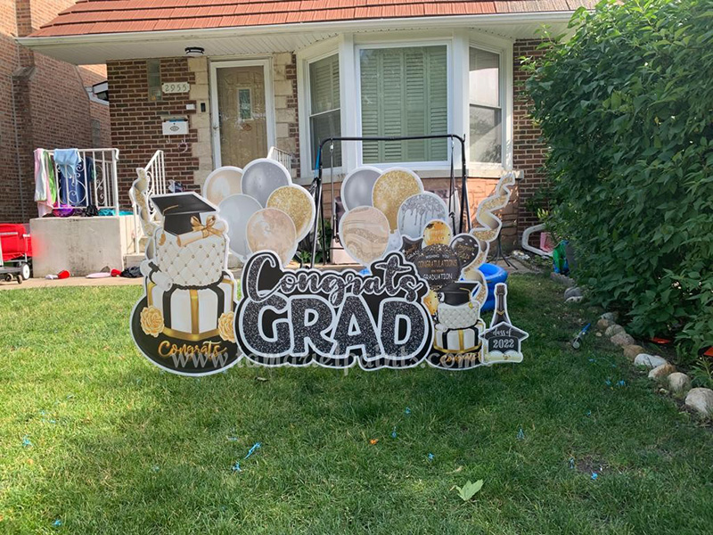 A photo of a custom made yard sign which reads Congrats Grad